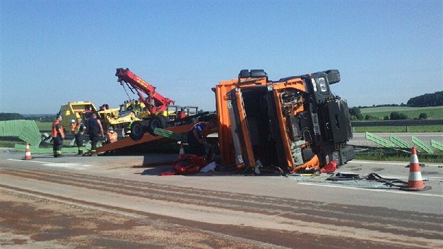 Z převráceného nákladního vozu spadl na dálnici D11 bagr a zablokoval provoz. (6. 6. 2014)