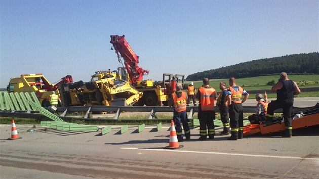 Z převráceného nákladního vozu spadl na dálnici D11 bagr a zablokoval provoz. (6. 6. 2014)