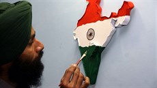 Indický umlec s papírovou mapou Indie, na které je vyznaen obrys nového státu...