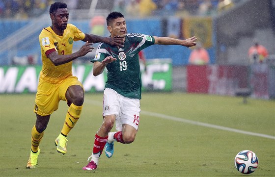 Oribe Peralta (vpravo) z Mexika uniká kamerunskému fotbalistovi Benoitu...