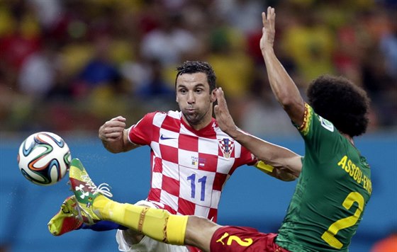Chorvatský fotbalista Darijo Srna (vlevo) bojuje o mí s Benoitem Assou-Ekottem...