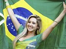 A fan holds up the Brazilian national flag as she waits for the 2014 World Cup...