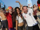 Soccer fans pose for a photo with a woman whose body is painted with Germany's...