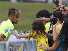 Brazilsk tonk Neymar se po trninku v Teresopolisu podepisuje fanoukm.
