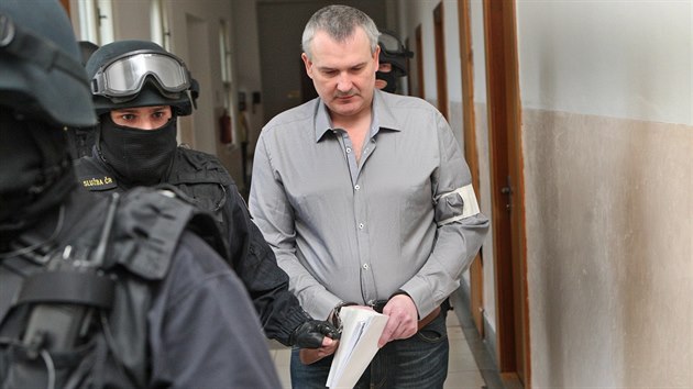 Těžkooděnci Vězeňské služby přivádějí Radka Březinu, který v Ostravě čelí obžalobě z pokusu uplácení dozorce. (13. června 2014)