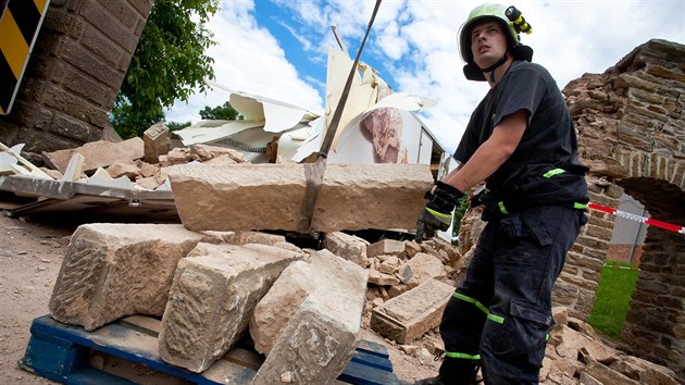 Hasiči odstraňovali za dohledu památkářů ze silnice pískovcové kvádry z pobořené brány v Nahořanech na Náchodsku. (16. 6. 2014)