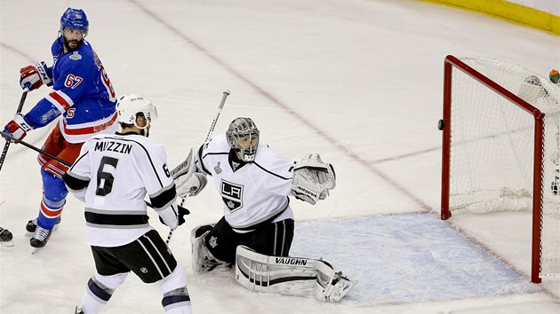 GL. Benoit Pouliot z New York Rangers usmruje puk za zda branke Los Angeles Jonathana Quicka.  