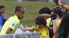 Brazilský útoník  Neymar se po tréninku v Teresopolisu podepisuje fanoukm.