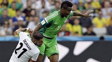 Nigérijec John Obi Mikel (v zeleném) běží na míčem, Íránec Aškan Dadžagá s ním...