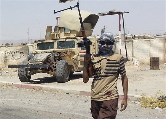 Ozbrojenec z ISIL stojí na stráži nedaleko rafinerie v Bajdží (19. června 2014).