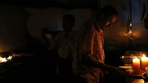 Kuchai v restauraci se sna dokonit objednvku pi vpadku proudu ve Caracasu (27. ervna 2014).