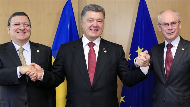 Jose Manuel Barroso (vlevo) a Herman Van Rompuy (vpravo) si podvaj ruce s prezidentem Ukrajiny Petro Poroenkem po podepsn ekonomick sti asocian dohody (27. ervna)