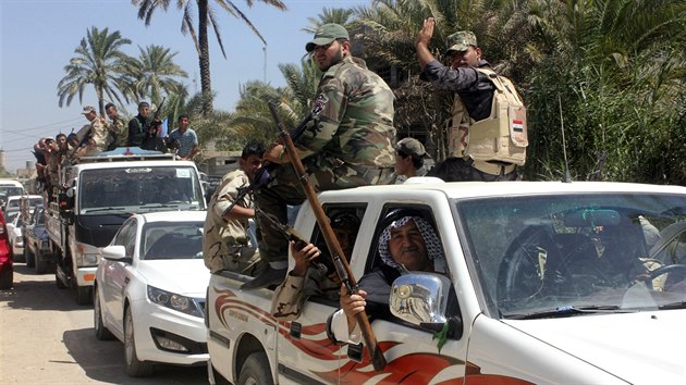 Dobrovolníci, kteří se připojili k armádě v boji proti radikálům z ISIL, projíždějí městem Bakuba (23. června 2014).