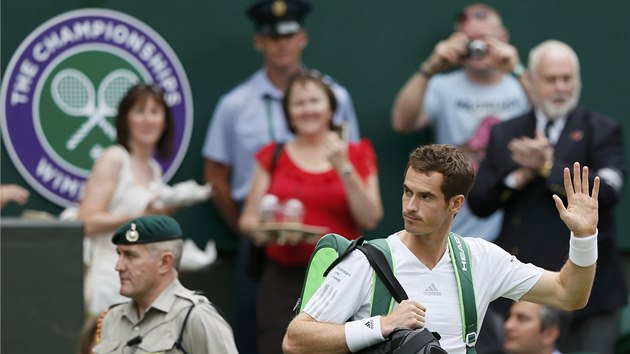 PICHZ OBHJCE TITULU. Andy Murray pichz na centrln kurt ve Wimbledonu ped utknm prvnho kola. 