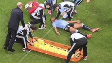 Uruguayec Álvaro Pereira leží na trávníku po úderu kolenem do hlavy. Za pár...