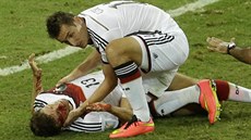Německý útočník Miroslav Klose se sklání ke svému spoluhráči Thomasi Müllerovi,...