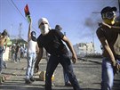 Palestinec hází kámeny na izraelské policisty bhem pohbu chlapce uneseného z...