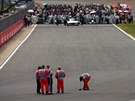 Poadatelé uklízejí tra po havárii Kimiho Räikkönena ve Velké cen Británie.