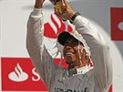 TSTÍ. Britský pilot Lewis Hamilton se polévá umivým vínem po vítzství ve...