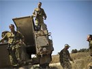 Izraeltí vojáci stojí na vrcholu obrnného transportéru poblí hranice pásma