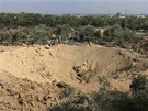 Malí Palestinci si prohlíí kráter, který byl údajn vyhloubený pi izraelském