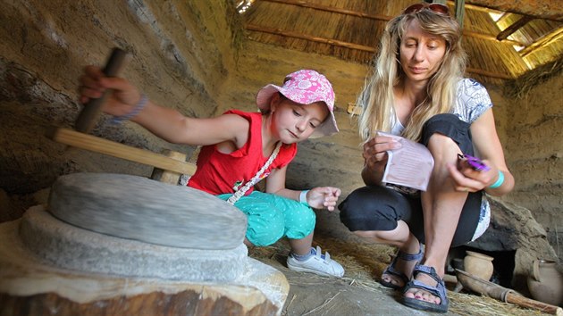 Osmiletá Michaela Písaříková si vyzkoušela mletí obilí v kamenném mlýnku.