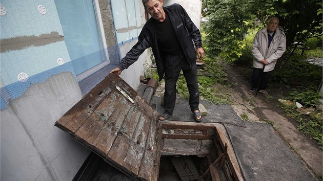 Obyvatel v�chodoukrajinsk�ho Don�cku ukazuje dv��ka do sklepa, kter� mu slou�il jako �kryt p�i ned�vn�ch n�letech (9. 7. 2014).