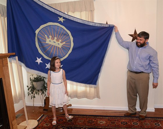 Jeremiah Heaton ukazuje vlajku Království Severního Súdánu, vlevo jeho dcera...