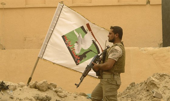 Dobrovolník z íitských milic loajálních duchovnímu Muktadu al-Sadrovi hlídkuje...