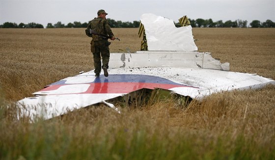 Ozbrojený proruský separatista stojí na jedné z trosek ze zíceného...