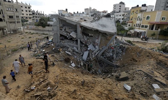 Palestinci se shromaují kolem trosek domu, který byl znien izraelským...