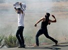 Mladí Palestinci ze Západního behu házejí kameny na policisty bhem...