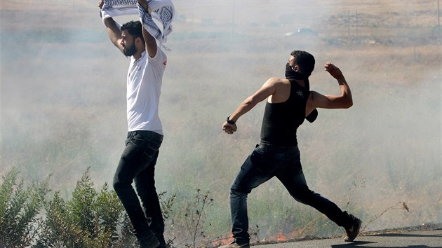Mlad Palestinci ze Zpadnho behu hzej kameny na policisty bhem demonstrace proti izraelskm nletm na Psmo Gazy (16. ervence 2014).