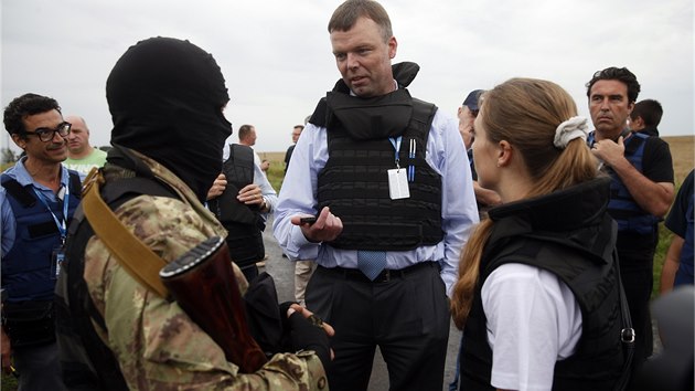 Pozorovatelé mise OBSE (v civilu) hovoří s proruským separatistou na místě