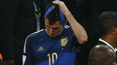 Argentinský útočník Lionel Messi si po finále MS sundává z krku stříbnou...