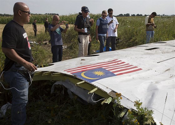 Malajsijtí vyetovatelé prohlíejí spolu s pozorovateli OBSE trosky Boeingu...