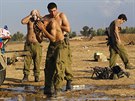 Izraeltí vojáci se oplachují vodou poté, co se vrátili z akce v Pásmu Gazy...
