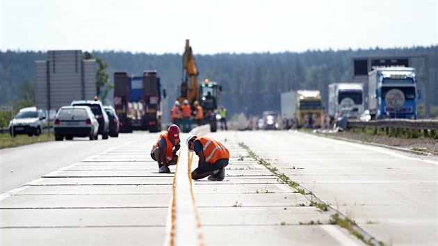Dělníci pokládají středové panely pro nové provizorní pruhy na modernizovaném úseku dálnice D1 na 163. kilometru u Velké Bíteše.