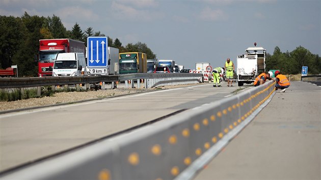 Dělníci pokládají středové panely pro nové provizorní pruhy na modernizovaném úseku dálnice D1 na 163. kilometru u Velké Bíteše.