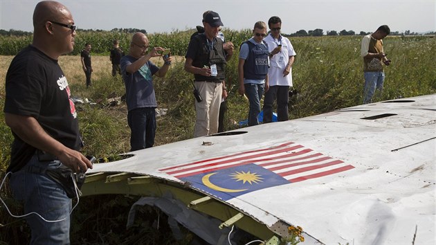 Malajsijští vyšetřovatelé prohlížejí spolu s pozorovateli OBSE trosky Boeingu 777 (Ukrajina, 23. července 2014).