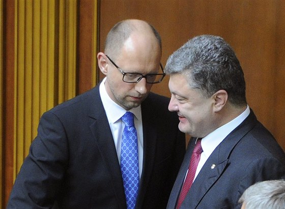 Ukrajinský premiér Arsenij Jaceuk (vlevo) hovoí bhem hlasování parlamentu o...