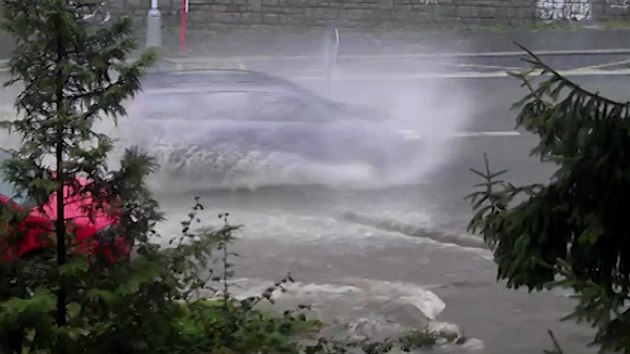 Voda po bouce se valí praskou Jeremenkovou ulicí.