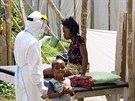 Zdravotník v ochranném obleku dává napít dívce nakaené ebolou na izolaní...