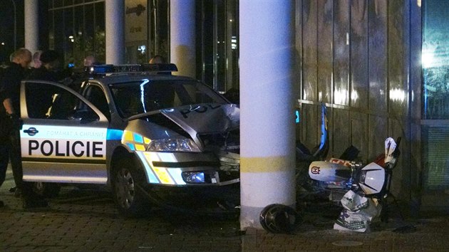 Honička policejního auta s motocyklem v Praze 11 skončila nárazem do sloupu u prodejny vířivek (6. srpna 2014).