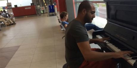 Cizinec, podle komentá Libanonec, baví hrou na piano spolucestující v...