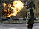 Proruský separatista v Doncku sleduje plameny z plynovodu zasaeného...