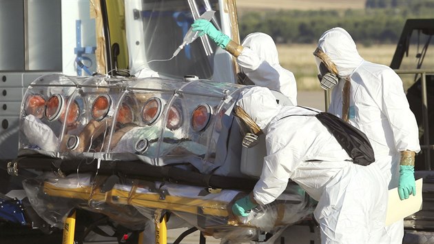 Zdravotnci ve specilnch oblecch pevej panlskho misione Miguela Pajarese z maridskho letit do nemocnice (7. srpna 2014).