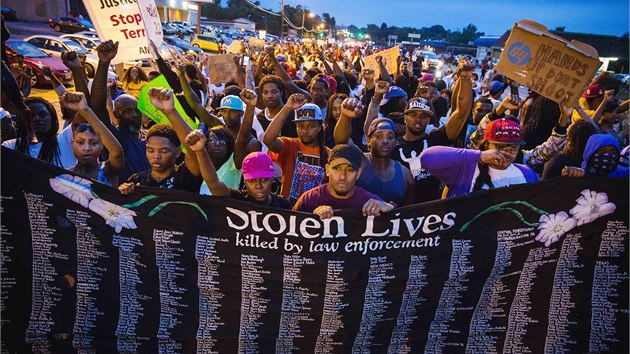 Demonstranti vzali do ulic i transparent se jmny lid, kte v USA zemeli bhem policejnch zsah. (16. srpna 2014)
