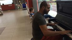 Cizinec, podle komentá�� Libanonec, baví hrou na piano spolucestující v...