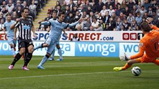 Fotbalista Manchesteru City David Silva (uprostřed) posílá míč do sítě...